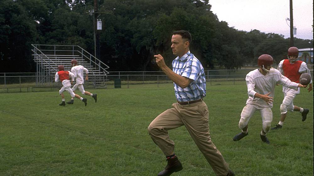 Forrest Gump (1994), Forrest Gump je prosťáček, který od dětství dělal, co se mu řeklo. Do života si tak odnesl několik ponaučení své maminky a osvědčené pravidlo, jež se mu hodí mnohokrát v nejrůznějších situacích: „Když se dostaneš do problémů, utíkej.“ Forrest proutíká školou, jako hráč amerického fotbalu i univerzitou, potom peklem vietnamské války a zoufalstvím nad matčinou smrtí. Vždycky je totiž někdo nebo něco, co po něm skutečně či obrazně „hází kameny“. Nakonec však Forrest poznává, že jsou i jiná řešení situací než útěk. Svůj život spojuje s kamarádkou ze školy Jenny, která pro něj zůstane provždycky jedinou láskou, s přítelem z vojny, černochem Bubbou, který dá směr jeho úvahám o lovu krevet, a s poručíkem Taylorem, jemuž ve Vietnamu zachrání život. Snímek je doslova prošpikován nejrůznějšími kulturními i společenskými odkazy, viděnými ovšem bizarně naivním pohledem hlavního hrdiny, úzce soustředěným na několik hlavních nehodnotících hledisek.
