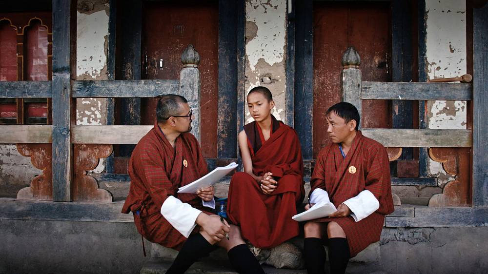 Agenti štěstí (2024).
Jak šťastná jste byla včera? Vlastníte ledničku? Kolik máte koz? Formulář pro výpočet štěstí zahrnuje celkem 148 podobných otázek. Starý mládenec Amber je jedním z několika desítek úředníků, kteří je pokládají obyvatelstvu Bhútánu. Spolu se svým kolegou navštěvuje malebné horské vísky a baví se s místními o jejich spokojenosti. Vláda doufá, že výzkum potvrdí pozici Bhútánu coby jedné z nejšťastnějších zemí světa. Pohledy do soukromí jednotlivých respodentů*ek i samotného Ambera, který touží po rodině a pečuje o nemocnou matku, ale ukazují, že život v himálajském království není pro všechny pohádkou.